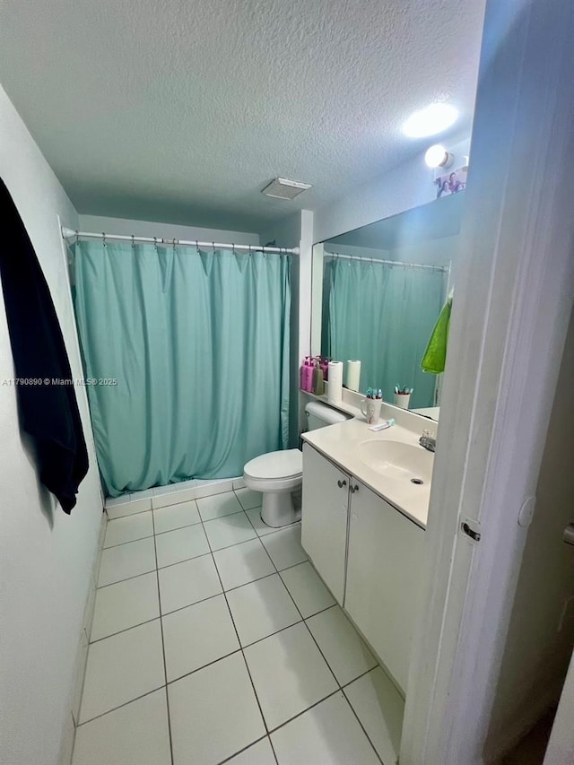 bathroom with toilet, a textured ceiling, tile patterned flooring, and vanity