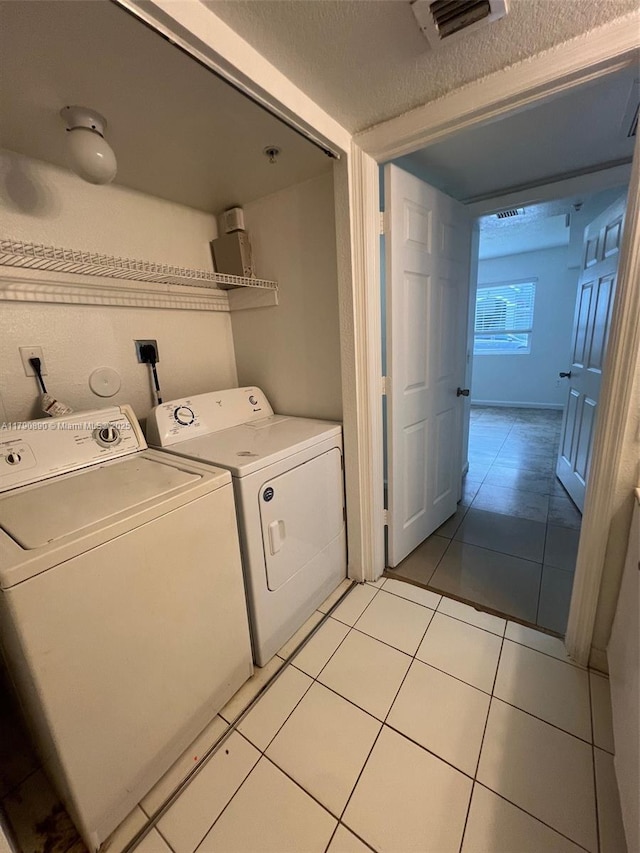 15422 SW 284th St Unit 7104, Homestead, FL 33033 - laundry room featuring separate washer and dryer, light tile patterned floors, and a textured ceiling