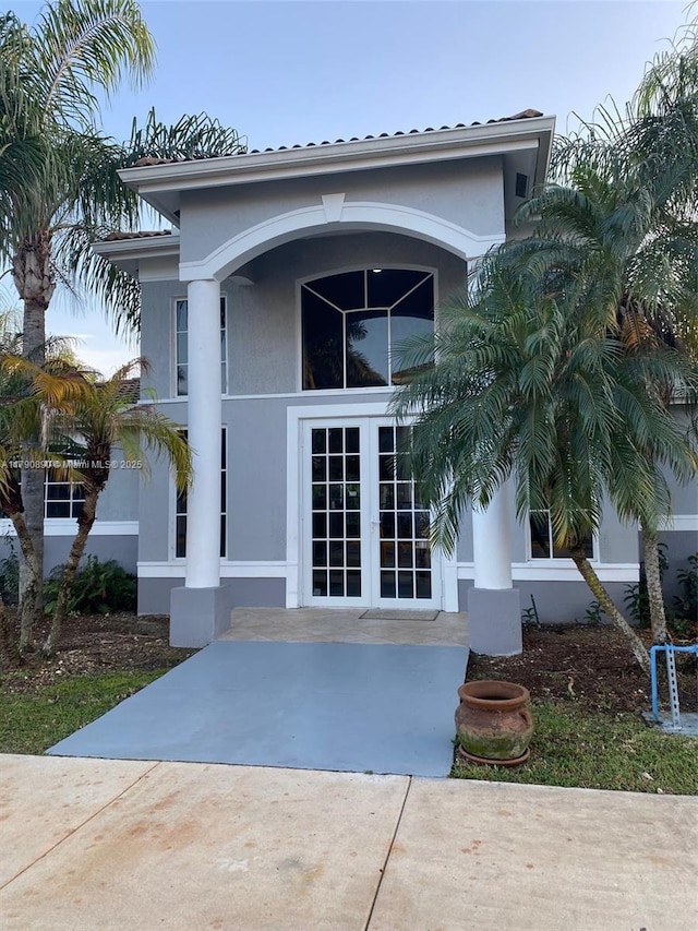entrance to property with french doors and stucco siding