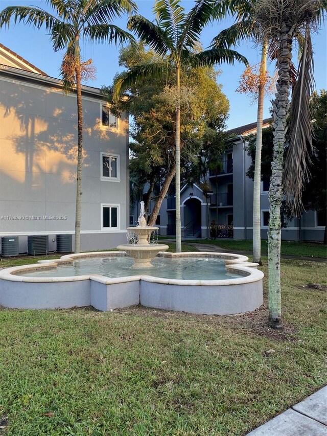 view of pool featuring a lawn and central AC