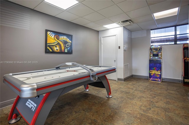 playroom featuring baseboards, visible vents, stone finish floor, and a paneled ceiling
