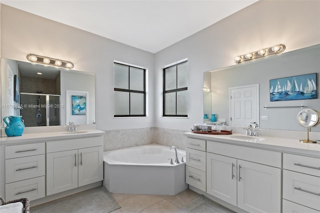 bathroom with tile patterned floors, two vanities, a shower stall, and a sink