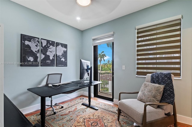 office space featuring baseboards, wood finished floors, and ceiling fan