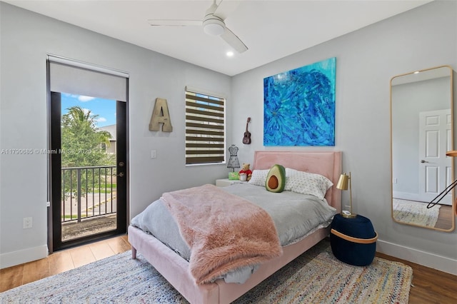 bedroom with wood finished floors, baseboards, access to exterior, and multiple windows