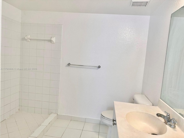full bathroom with tiled shower, vanity, tile patterned floors, toilet, and visible vents