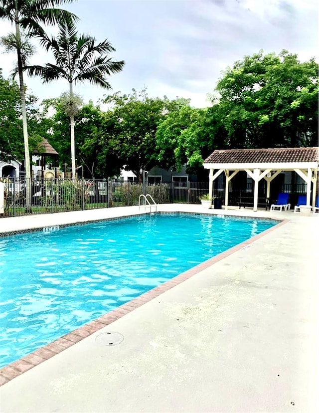 community pool featuring fence and a patio area