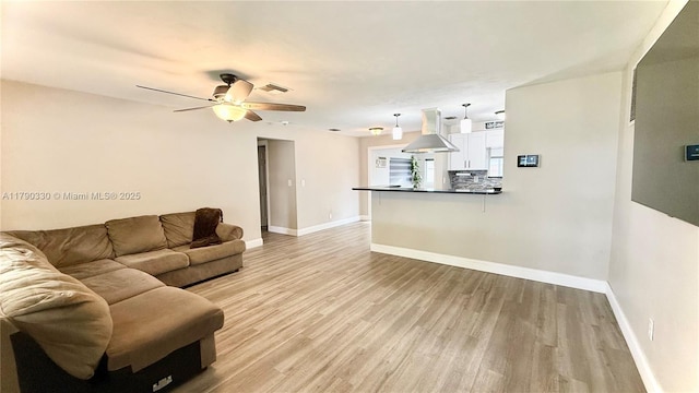 living area featuring visible vents, ceiling fan, baseboards, and light wood-type flooring