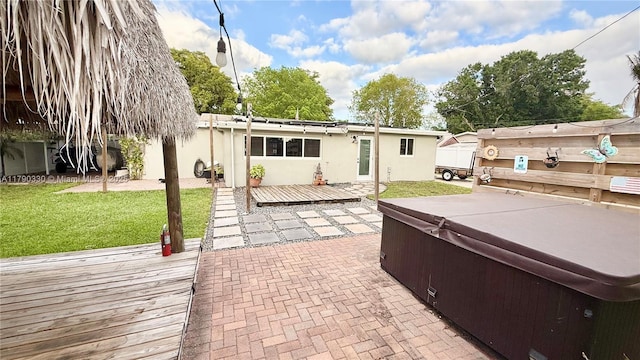 view of patio / terrace with fence, a wooden deck, and a hot tub