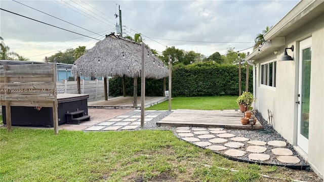 view of yard with a deck, a fenced backyard, and a hot tub