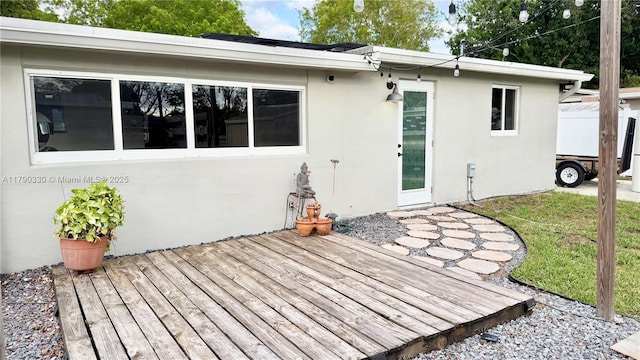 exterior space with a deck and stucco siding