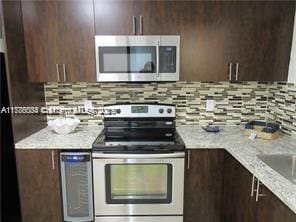 3100 NW 42nd Ave Unit D202, Coconut Creek, FL 33066 - kitchen featuring appliances with stainless steel finishes, modern cabinets, and dark brown cabinetry