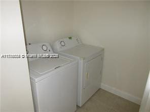 3100 NW 42nd Ave Unit D202, Coconut Creek, FL 33066 - laundry area featuring washer and dryer, laundry area, and baseboards