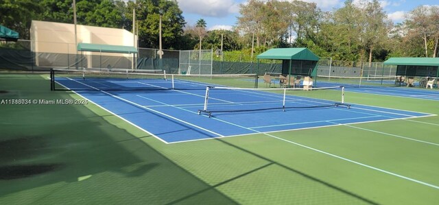 3100 NW 42nd Ave Unit D202, Coconut Creek, FL 33066 - view of tennis court featuring community basketball court and view of wooded area