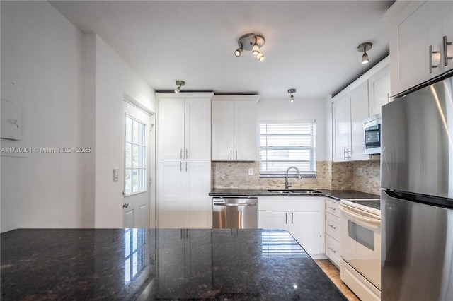 7850 Byron Ave Unit 207, Miami Beach, FL 33141 - kitchen with stainless steel appliances, a sink, decorative backsplash, and white cabinetry