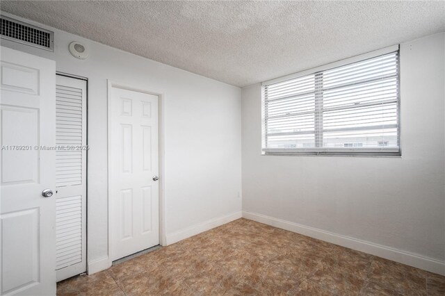 7850 Byron Ave Unit 207, Miami Beach, FL 33141 - unfurnished bedroom with a textured ceiling and baseboards