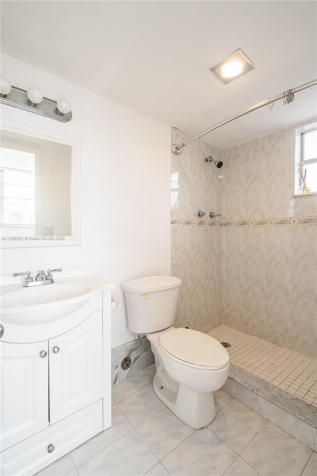 7850 Byron Ave Unit 207, Miami Beach, FL 33141 - bathroom featuring a tile shower, toilet, vanity, and tile patterned flooring