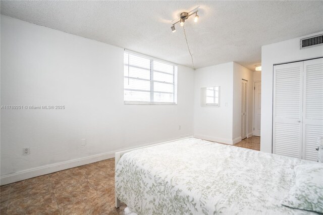 7850 Byron Ave Unit 207, Miami Beach, FL 33141 - unfurnished bedroom with a textured ceiling, two closets, and baseboards