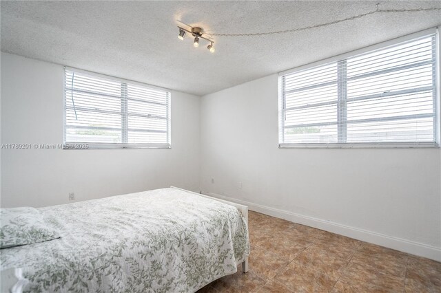 7850 Byron Ave Unit 207, Miami Beach, FL 33141 - bedroom with baseboards and a textured ceiling