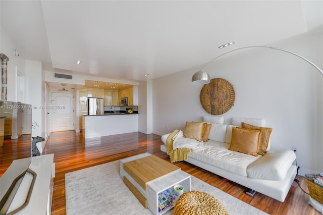 living room with visible vents and wood finished floors