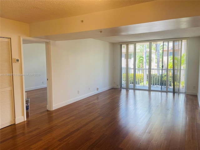 unfurnished room with dark wood-style floors and baseboards