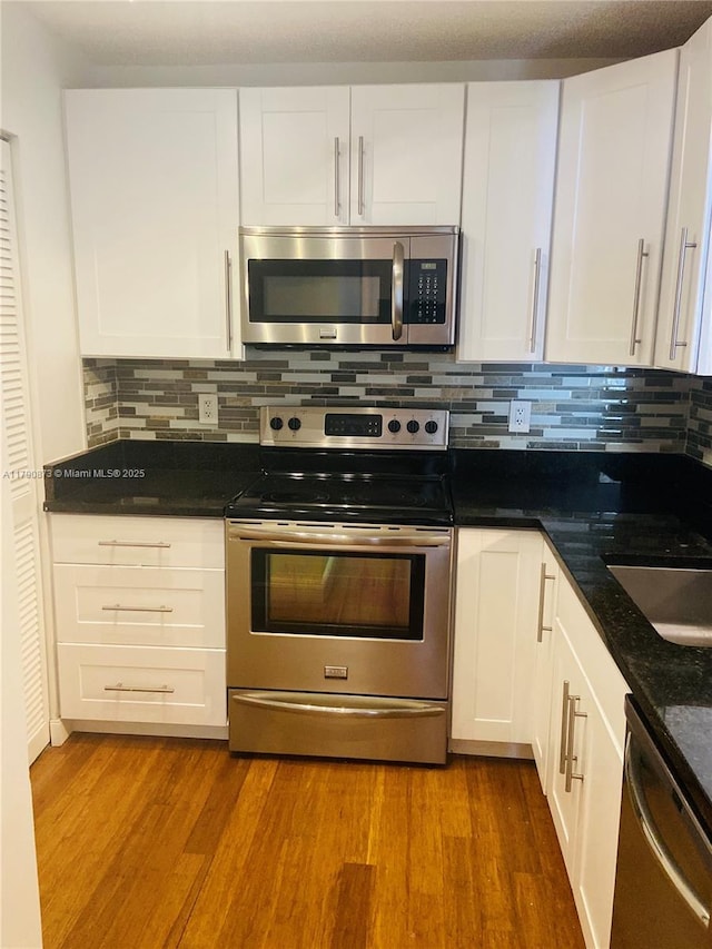 kitchen featuring appliances with stainless steel finishes, tasteful backsplash, and white cabinets