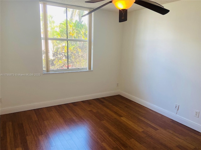 empty room with a ceiling fan, wood finished floors, and baseboards