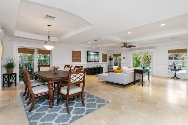 dining space featuring a ceiling fan, visible vents, a healthy amount of sunlight, and a decorative wall