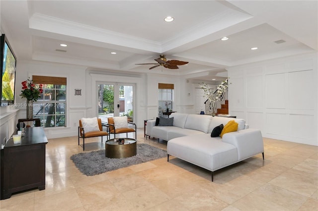 living area with stairs, ceiling fan, ornamental molding, and a decorative wall