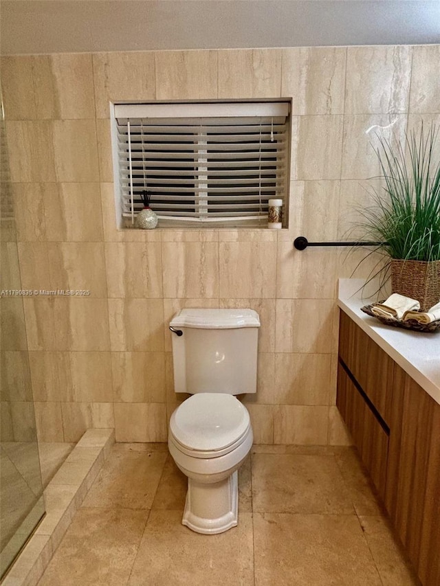 full bathroom featuring vanity, toilet, and tiled shower