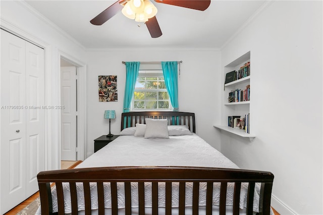 bedroom featuring a ceiling fan, ornamental molding, wood finished floors, and a closet