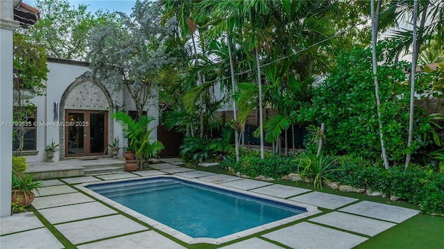 pool featuring french doors, fence, and a patio area