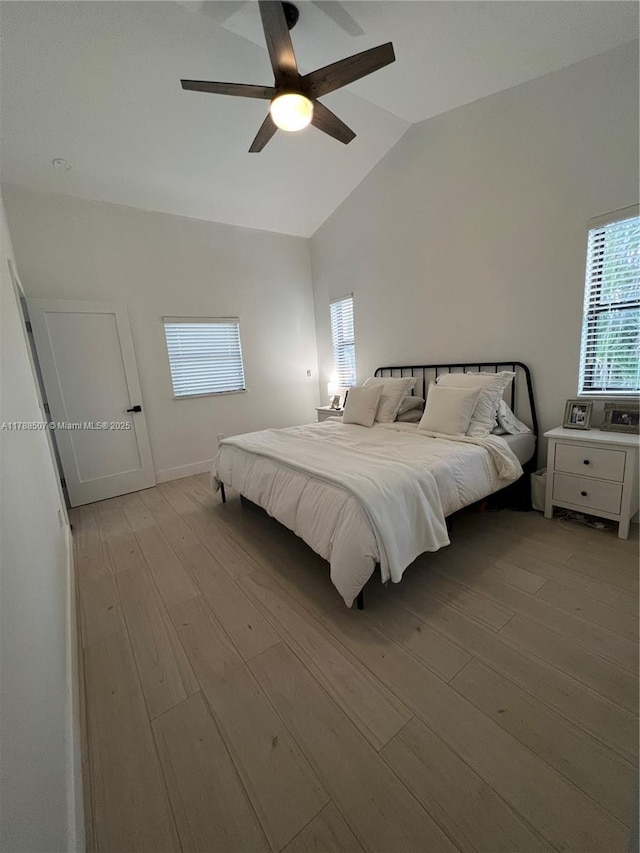 bedroom featuring ceiling fan, light wood finished floors, and vaulted ceiling
