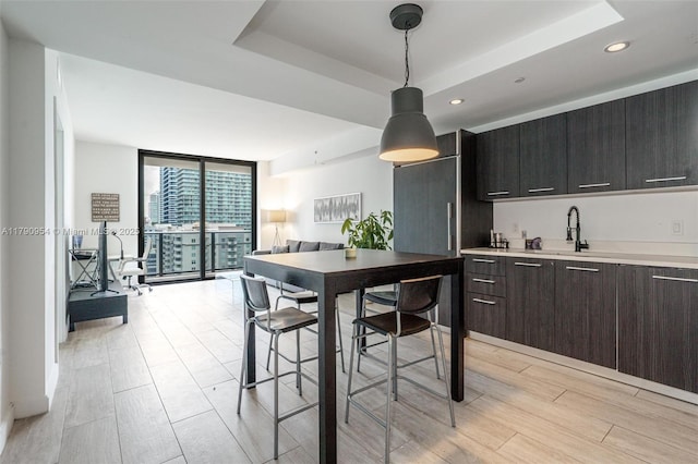 45 SW 9th St Unit 1205, Miami, FL 33130 - kitchen featuring expansive windows, dark brown cabinetry, pendant lighting, light countertops, and a tray ceiling