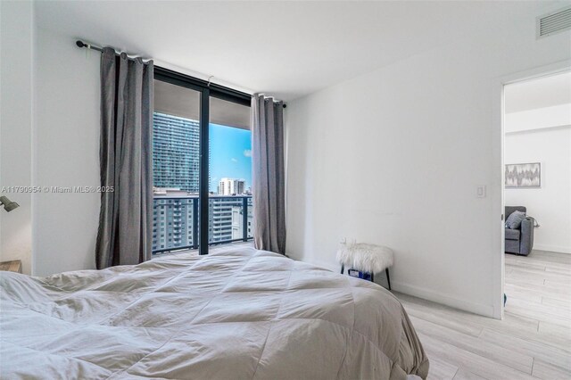45 SW 9th St Unit 1205, Miami, FL 33130 - bedroom featuring a wall of windows, wood finished floors, and access to exterior