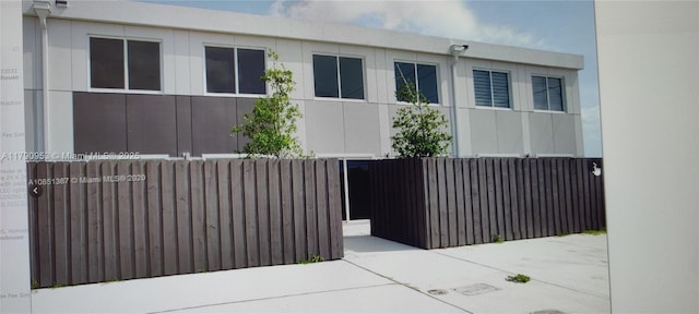 view of side of home featuring stucco siding and fence