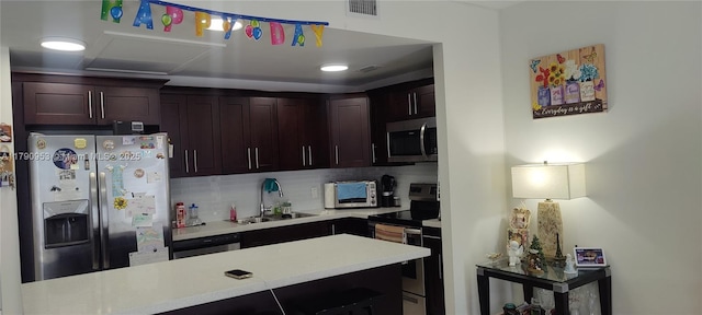 kitchen with a sink, tasteful backsplash, visible vents, light countertops, and appliances with stainless steel finishes