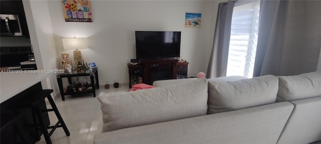 living area featuring light tile patterned floors and a healthy amount of sunlight