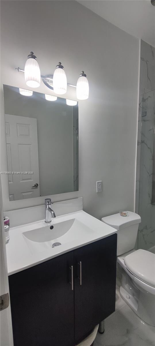 full bath with toilet, vanity, marble finish floor, and a marble finish shower