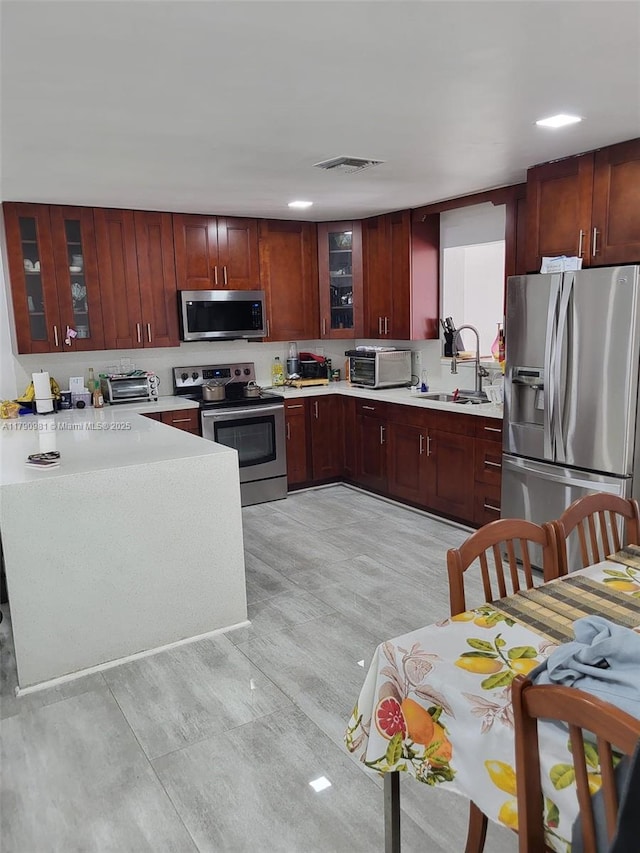 kitchen featuring light countertops, a sink, appliances with stainless steel finishes, and visible vents