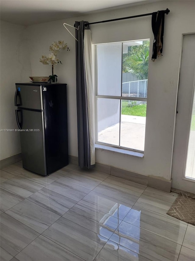 unfurnished dining area featuring light tile patterned floors and plenty of natural light
