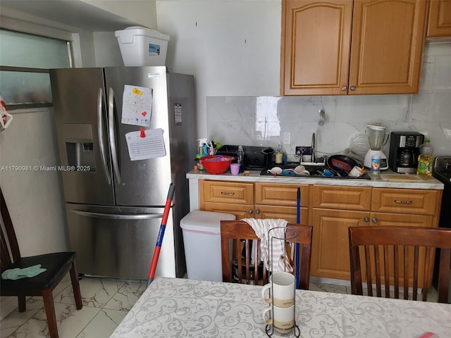 kitchen featuring light countertops, marble finish floor, and stainless steel fridge with ice dispenser