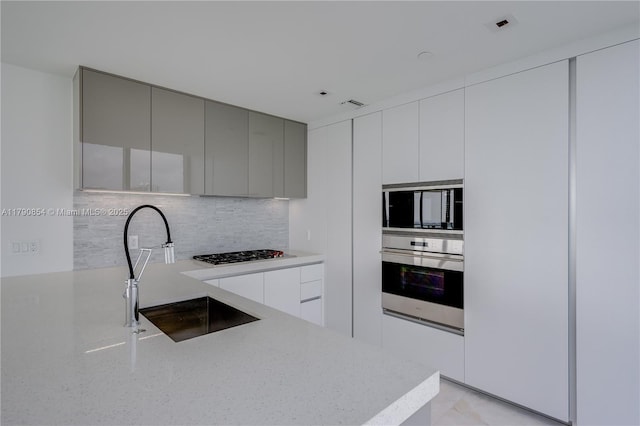 kitchen featuring a sink, gray cabinetry, gas cooktop, modern cabinets, and stainless steel oven