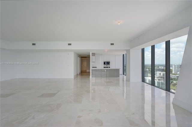 unfurnished living room featuring visible vents and marble finish floor