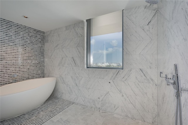 full bathroom with a tile shower and a freestanding tub