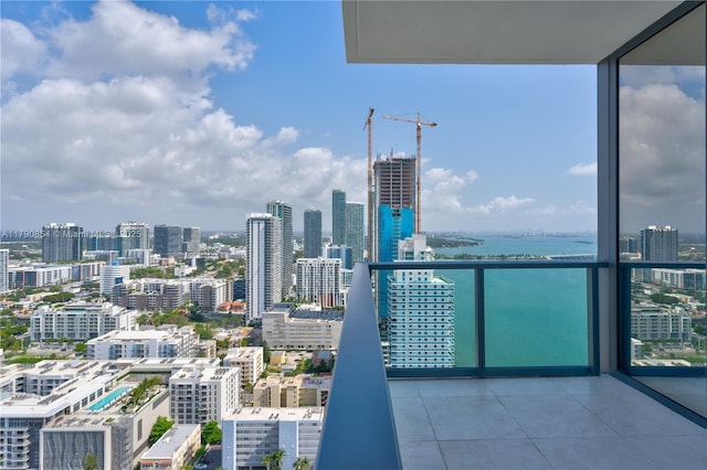 balcony featuring a water view and a city view