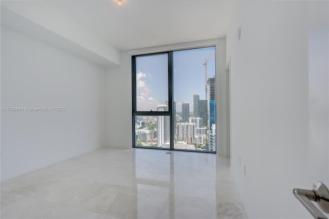 spare room with a view of city and expansive windows