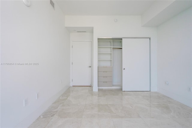 unfurnished bedroom featuring a closet and visible vents