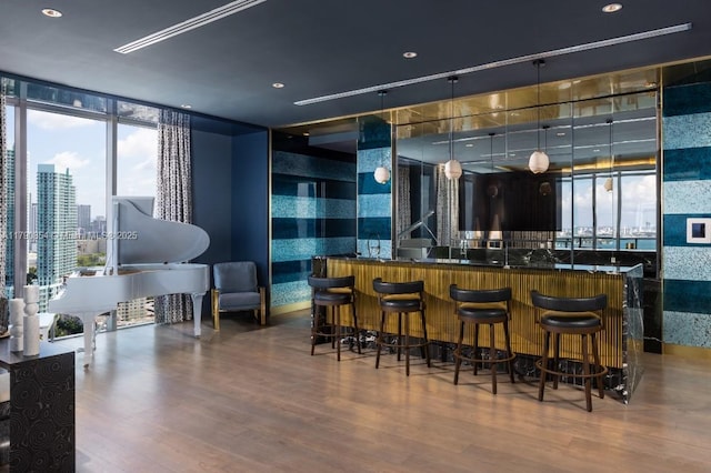 bar with wet bar, recessed lighting, wood finished floors, and floor to ceiling windows