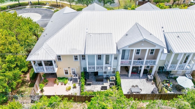 rear view of house featuring metal roof, a patio, and a fenced backyard