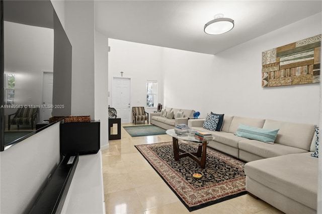 living room with baseboards, light tile patterned floors, and a towering ceiling